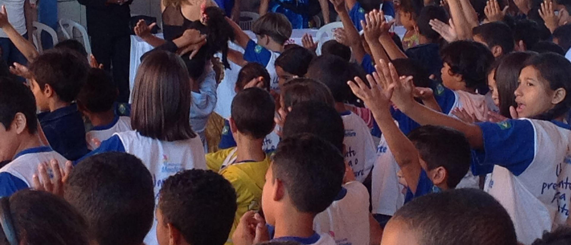 children with raise arms in brazil